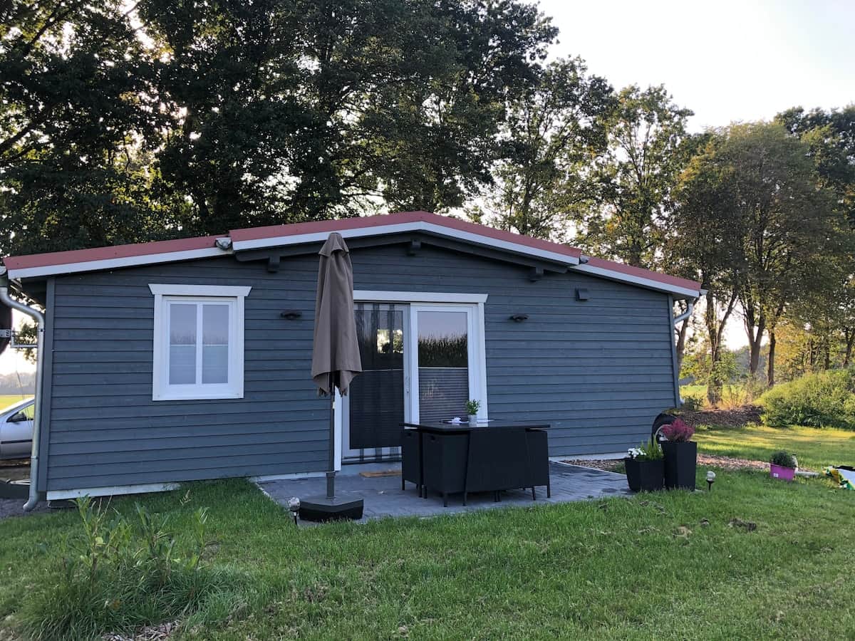 Außenansicht des Tiny House mit Terrasse und Sonnenschirm
