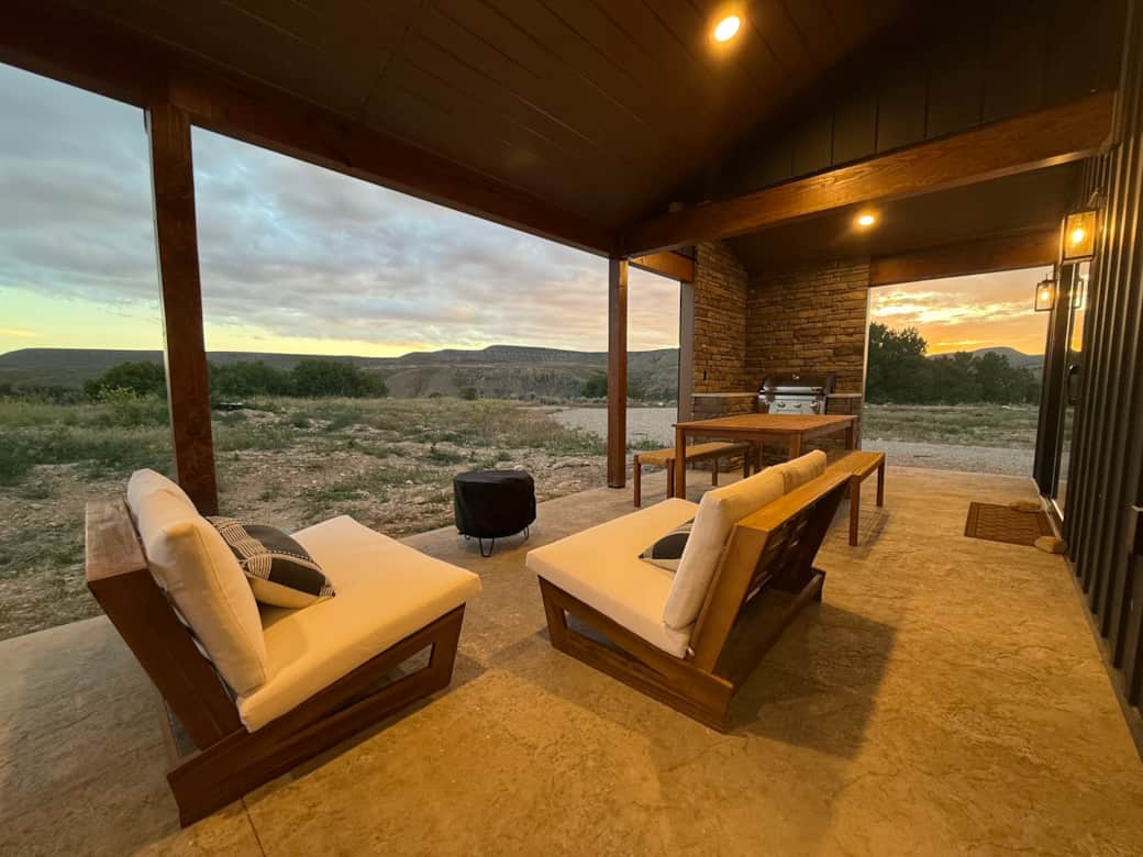Comfy seating, dining table with benches, and sunset views