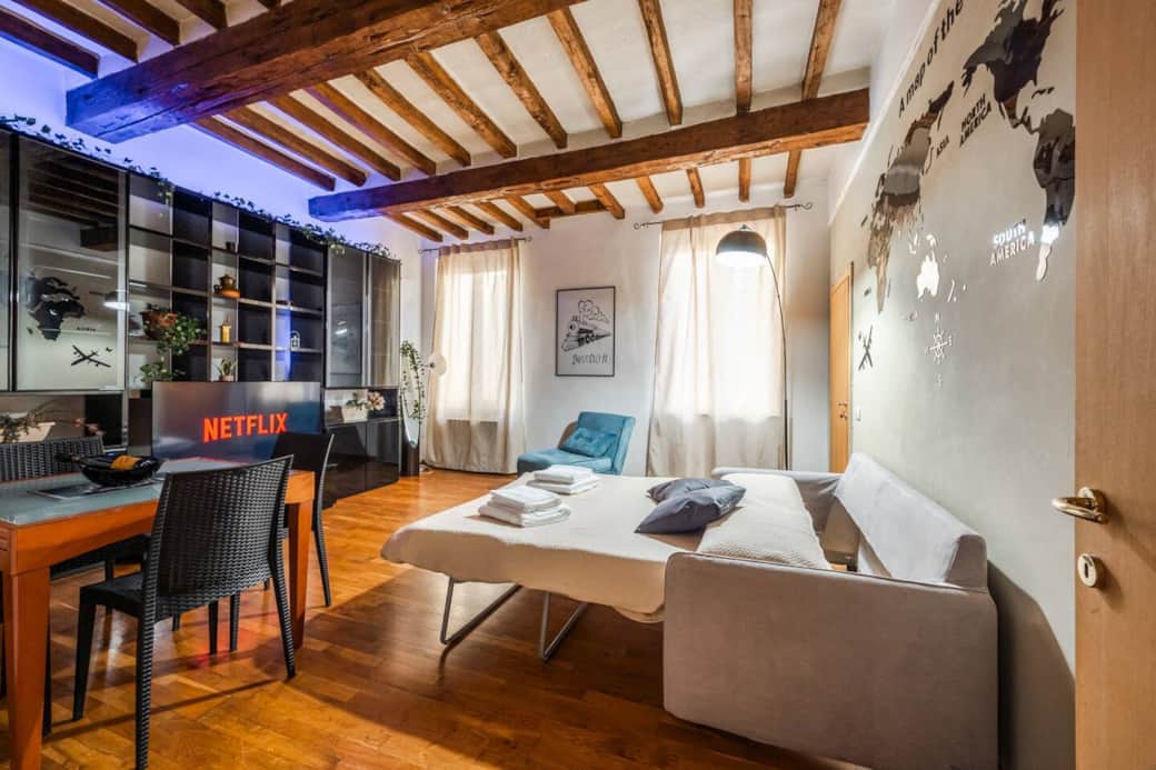 Il divano letto è aperto, pronto per la notte. La TV da 55 pollici e l'atmosfera tranquilla rendono il salotto ideale per il relax.