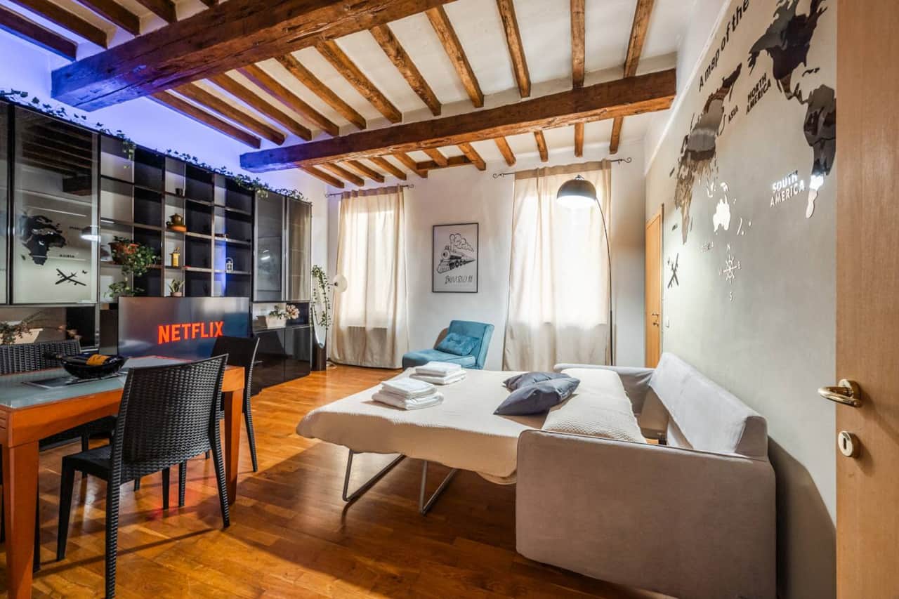 Il divano letto è aperto, pronto per la notte. La TV da 55 pollici e l'atmosfera tranquilla rendono il salotto ideale per il relax.