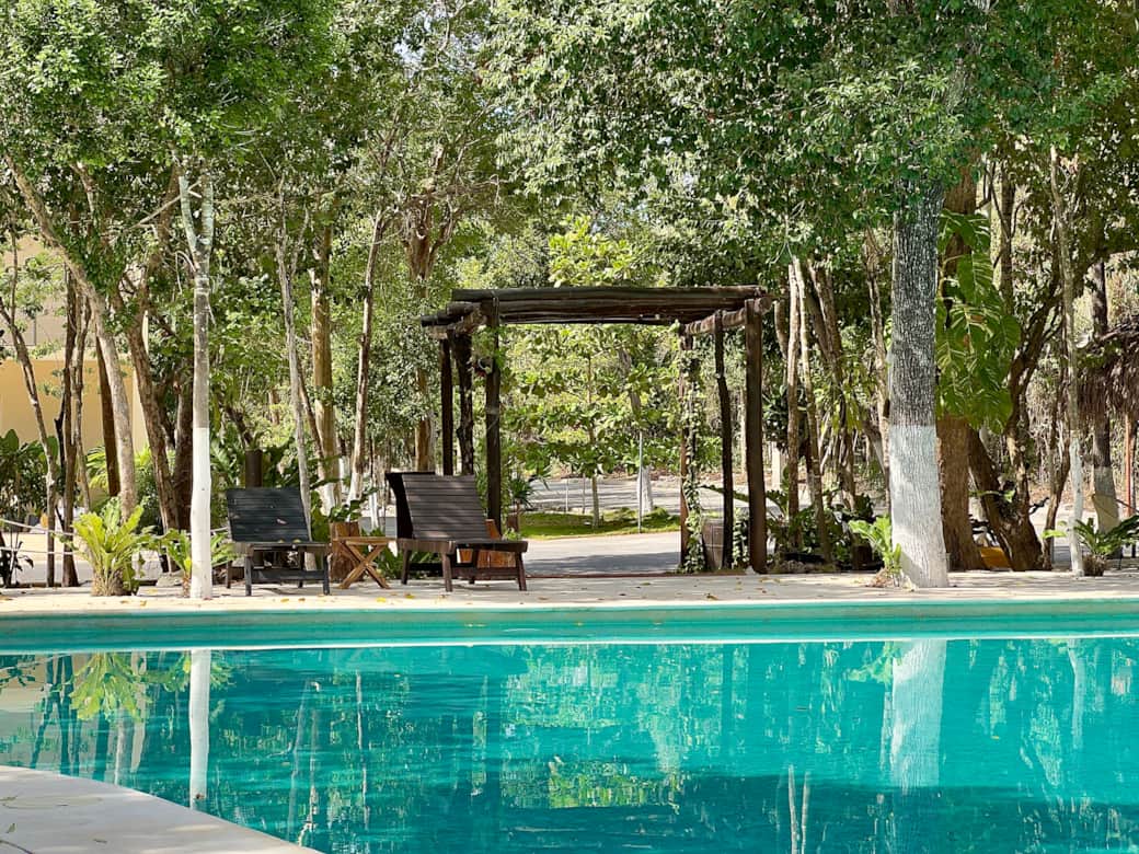 Common area with pools, lounge chairs, palapas, balconies and garden