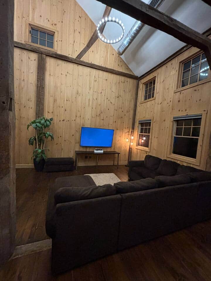 This inviting living room offers a plush L-shaped sofa designed for comfort, along with a large screen TV for streaming your favorite shows. The space is cozy, open, and perfect for gathering, lounging, or enjoying a quiet night in.