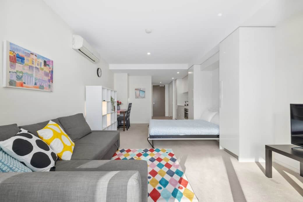 Enjoy a bright, welcoming living space with a comfy sofa, colorful decoration, and natural light flooding in. The perfect spot to relax, read a book, or watch TV after a busy day exploring the city. Feels just like home—with extra style and comfort.