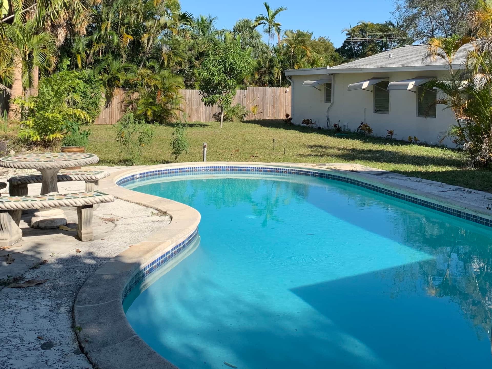 Before renovation pool area at Casa Citron showing cracked concrete flooring in Fort Lauderdale
