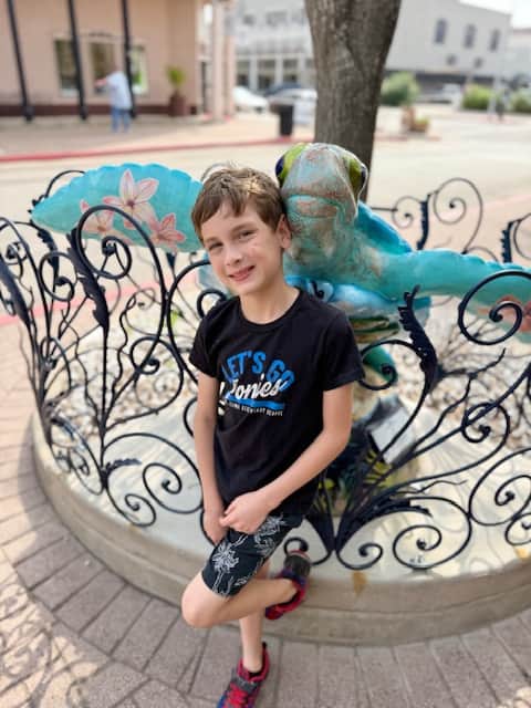 Boy posing near sea turtle art in Galveston
