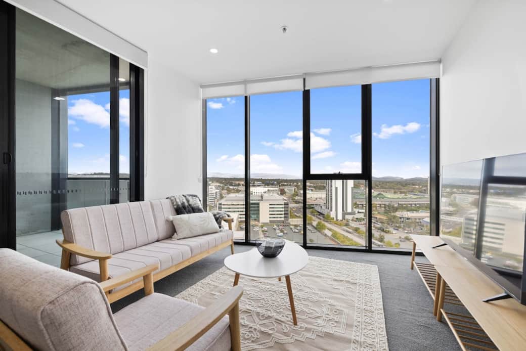 This spacious living room offers breathtaking views of the city through the floor-to-ceiling windows. Featuring a comfortable sofa and a stylish table, creates a welcoming atmosphere. This room is designed to impress and provide a memorable stay.