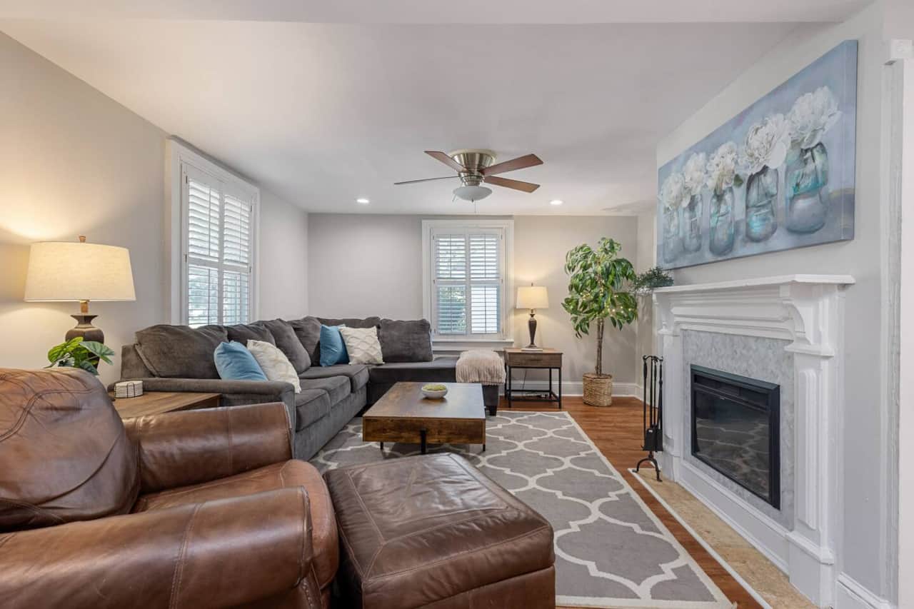 Living Room with leather recliner, oversized sofa, ceiling fan and electric fireplace.