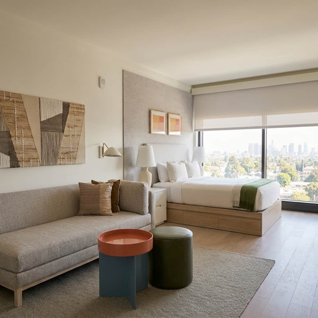 Stylish furnished living room with large windows and city views.
