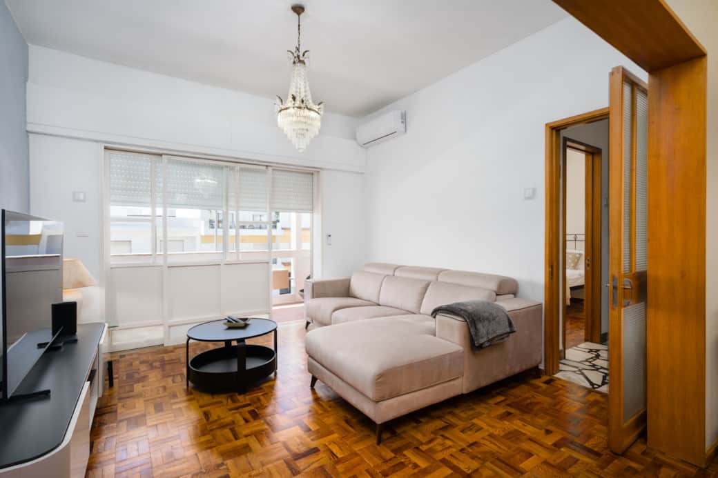 Heller Wohnbereich mit Flachbild-TV und direktem Zugang zum Balkon.