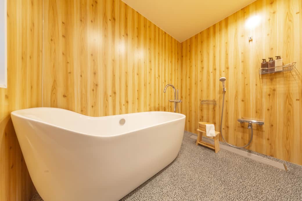 Rejuvenate in a luxurious deep tub surrounded by warm wood textures and peaceful ambiance