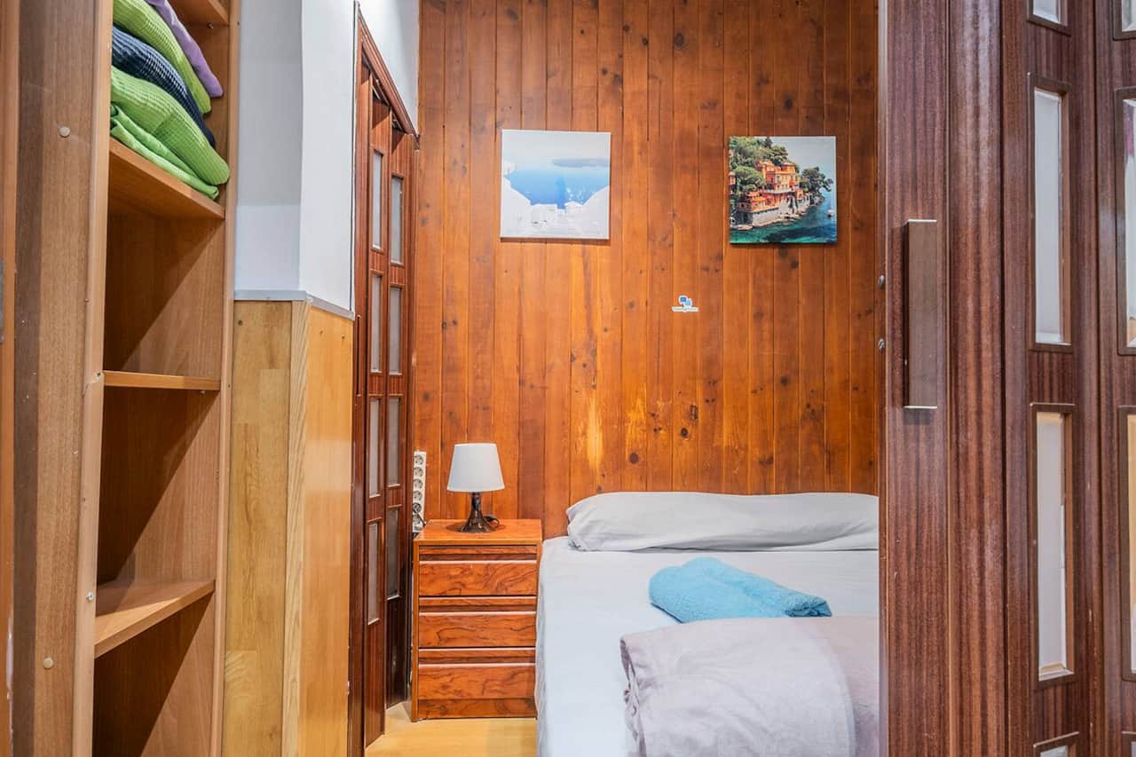 Dormitorio con estantería y separador de paneles