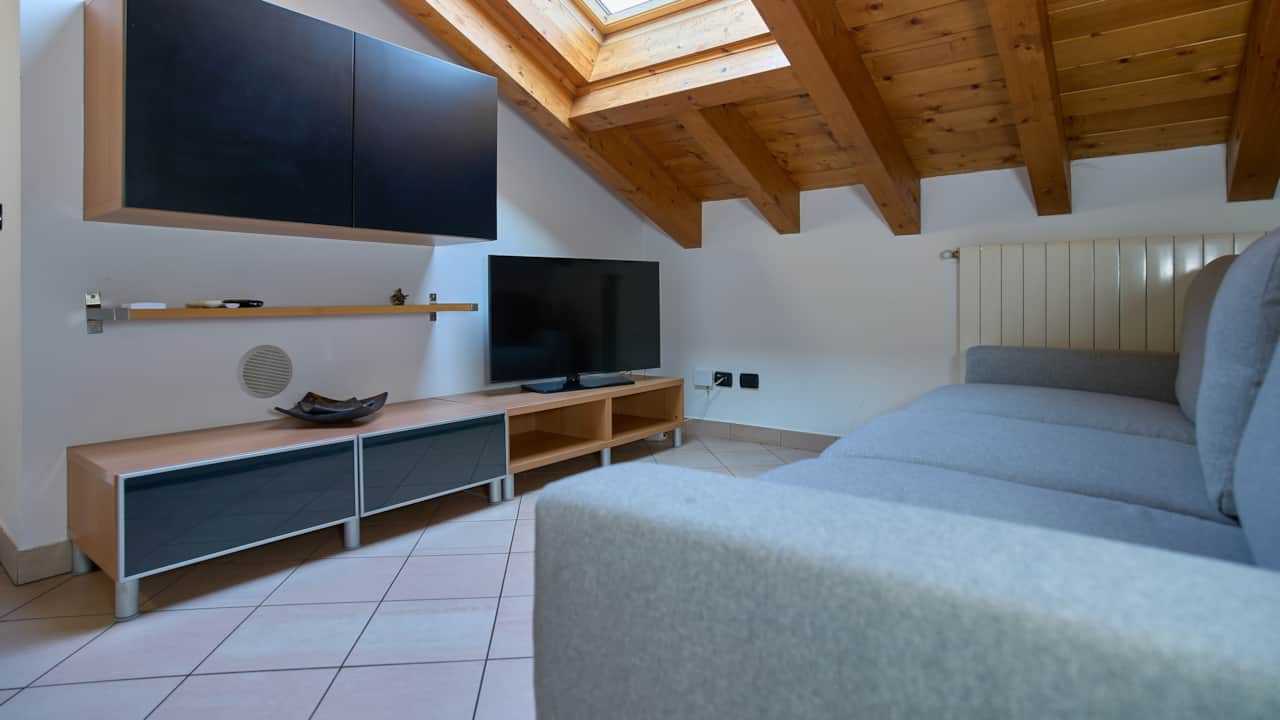 Wohnzimmer mit Holzbalkendecke und Fernseher