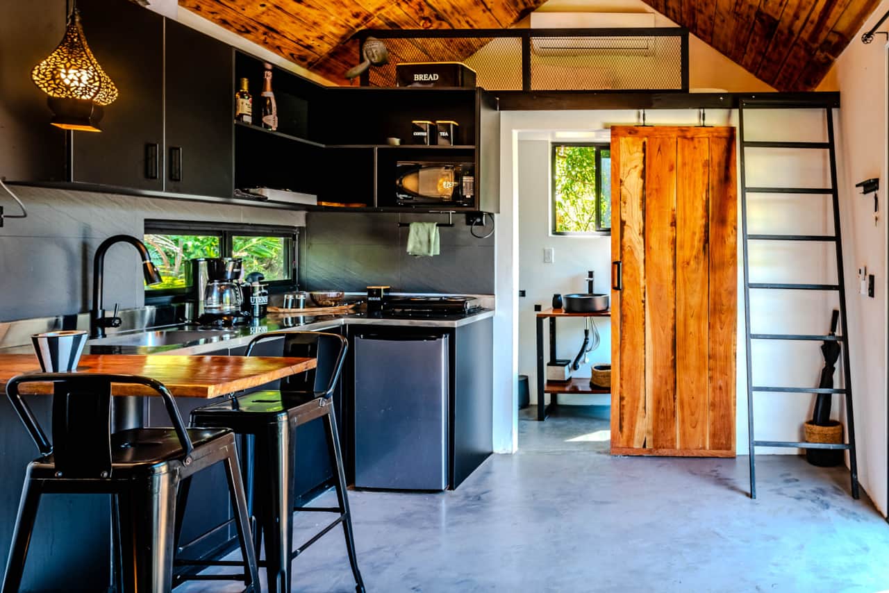 Full kitchen and loft ladder inside our Scandinavian eco cabin in Valle de Antón, Panama