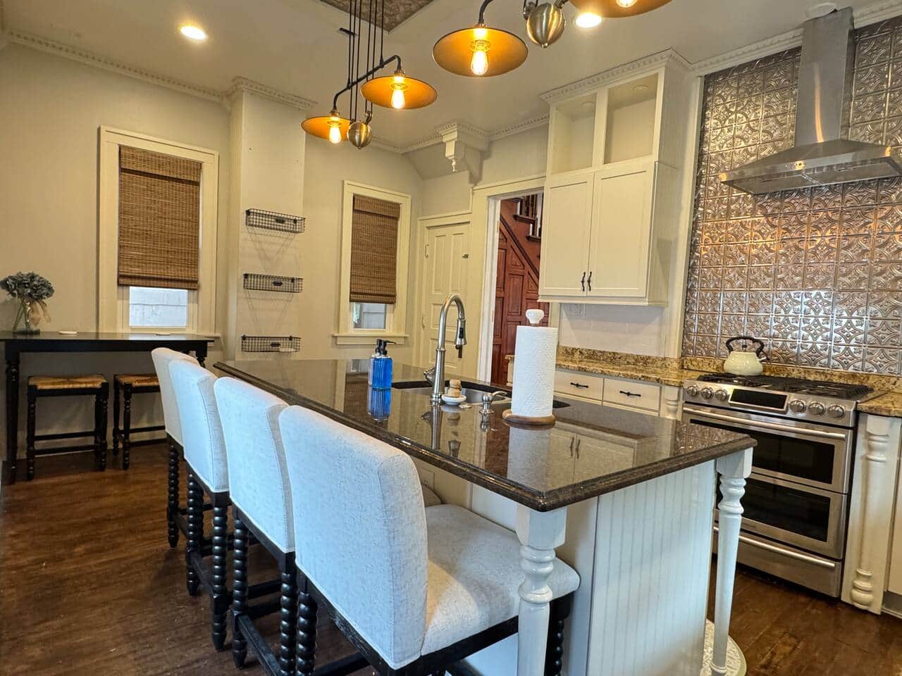 Spacious and stylish kitchen with granite countertops, large center island, and modern pendant light