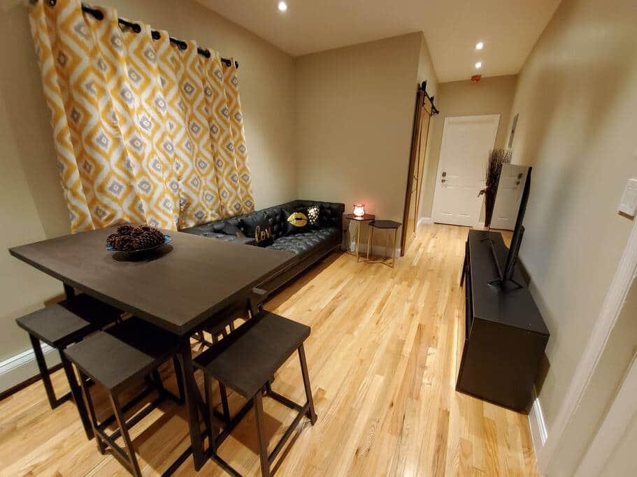 The Junction living room — bright, modern, near J train
