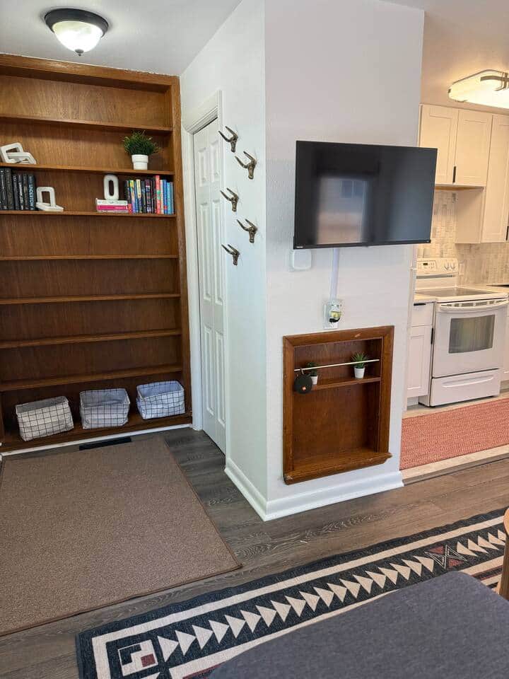 This cozy corner has it all, from a smart TV to shelves with books, baskets, and a little greenery. 