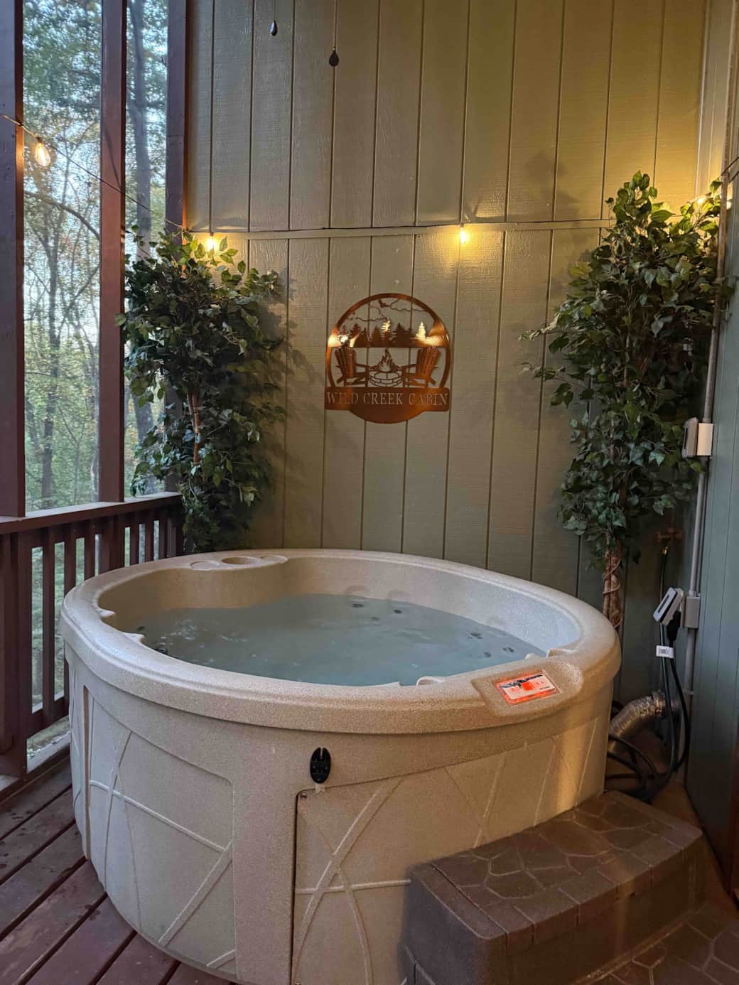 Screened in porch with hot tub and wall mounted tv.