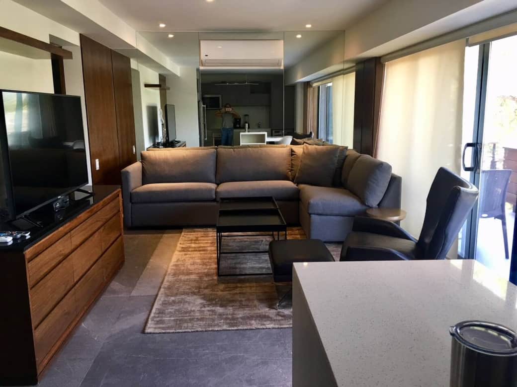 Sala con sillones en L y acceso a balcón 