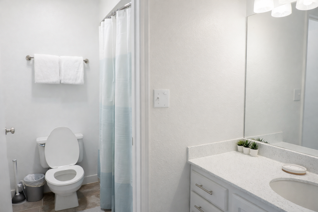 Bright, minimalist bathroom featuring a  tub and all the essentials thoughtfully stocked.