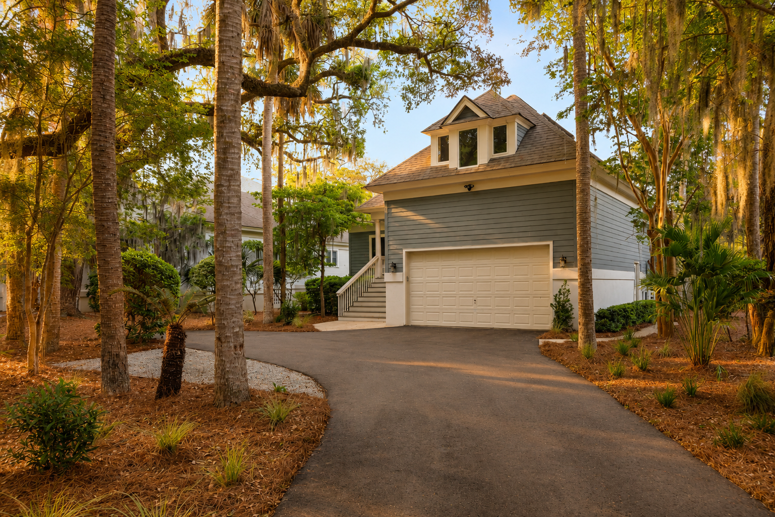 Arrive along the private driveway with an attached garage surrounded by mature trees and landscaping