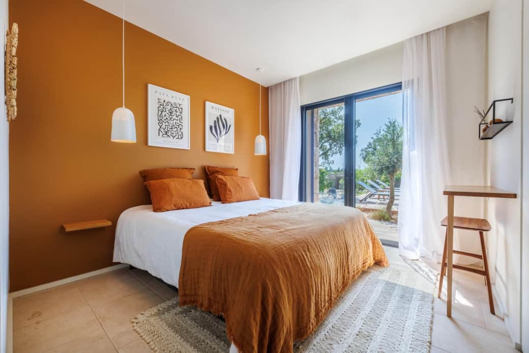 Chambre double chaleureuse aux tons terracotta avec vue piscine