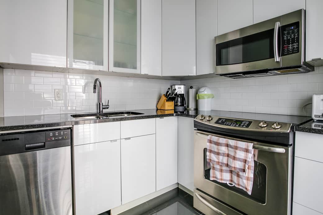 Compact and sleek kitchen in a Toronto cozy apartment, fully equipped for short stays.