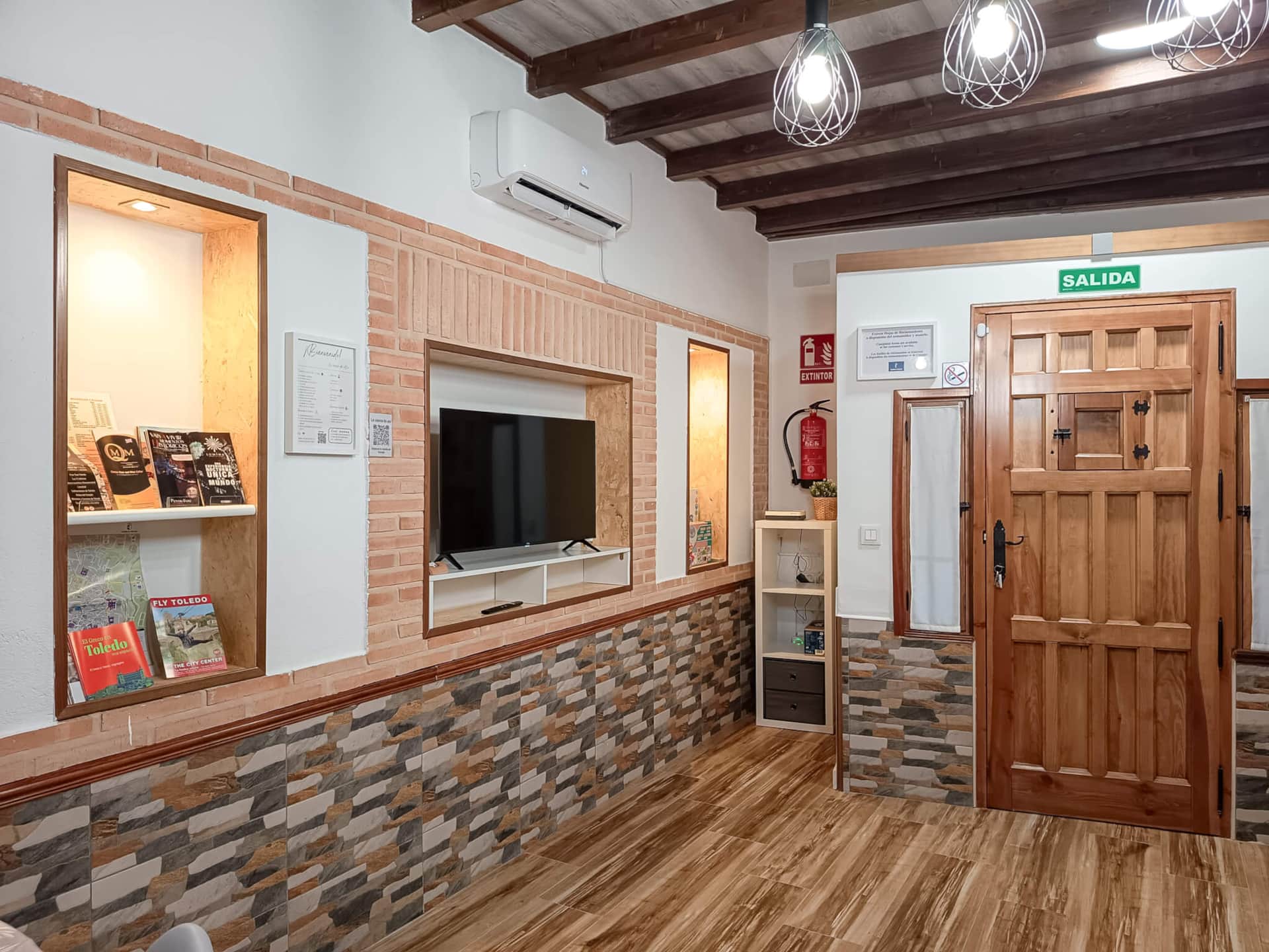 Salón con TV de La Casita de Ale en Polán con decoración rústica y zona de descanso