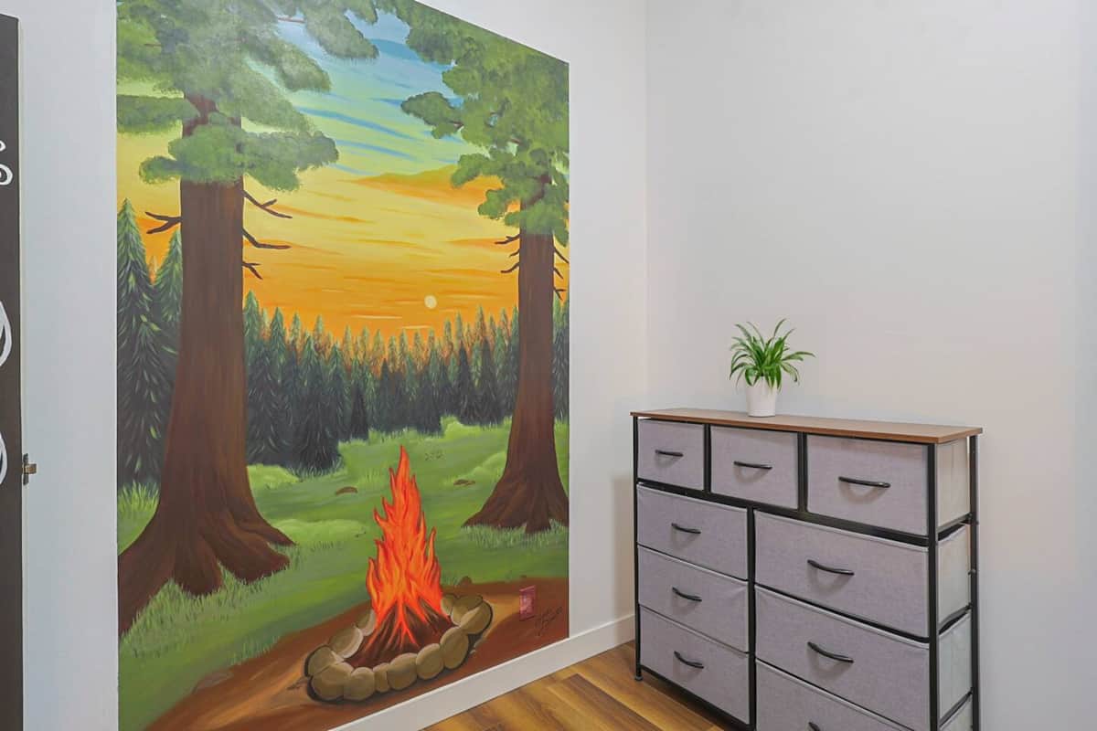 Mural chaleureux de feu de camp au coucher du soleil — peint par une artiste locale.