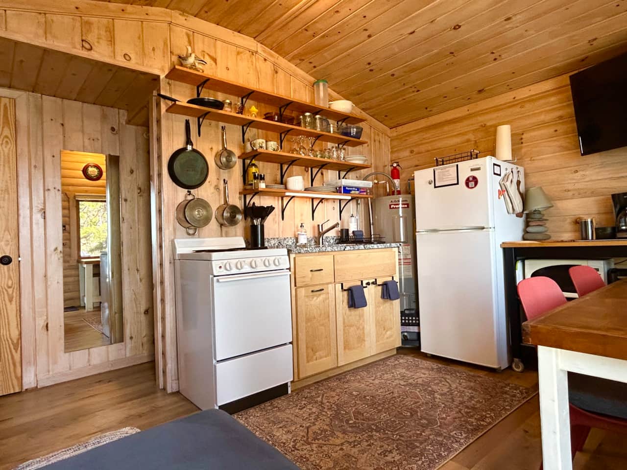 Kitchen space with updated granite counter and open shelving. All you need to make your "cabin" meal