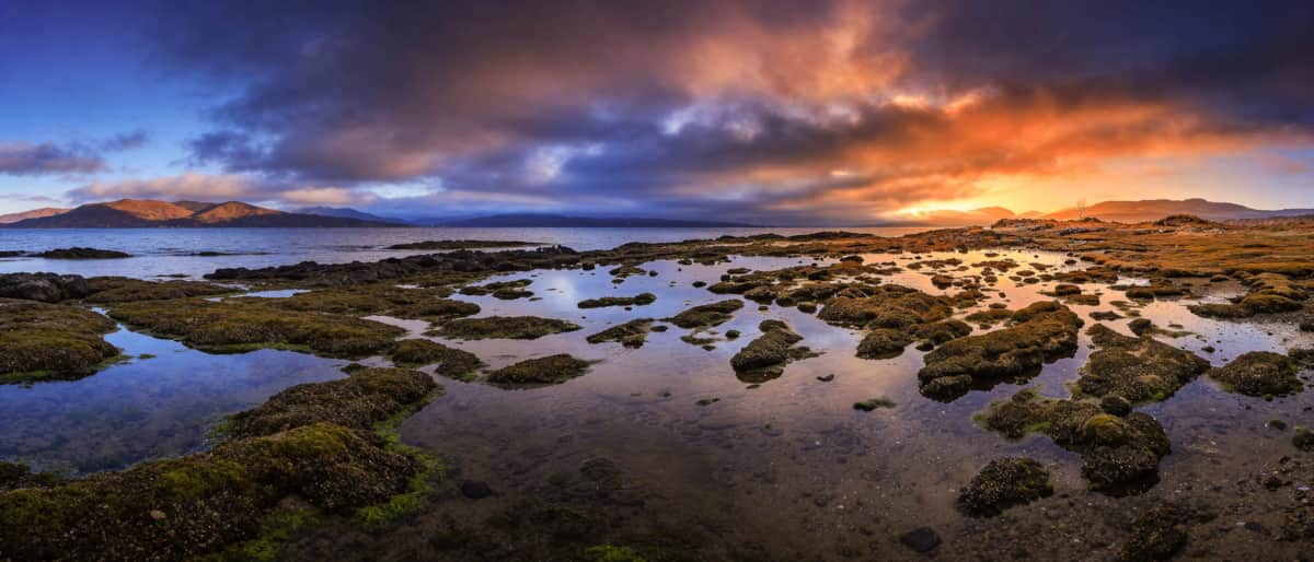 Tidal pools along the shore at Aros Mains beneath a colourful evening sky