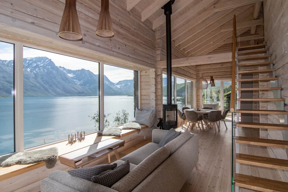 Wohnzimmer in Nordlys mit Kaminofen und Sitzbank am Panoramafenster
