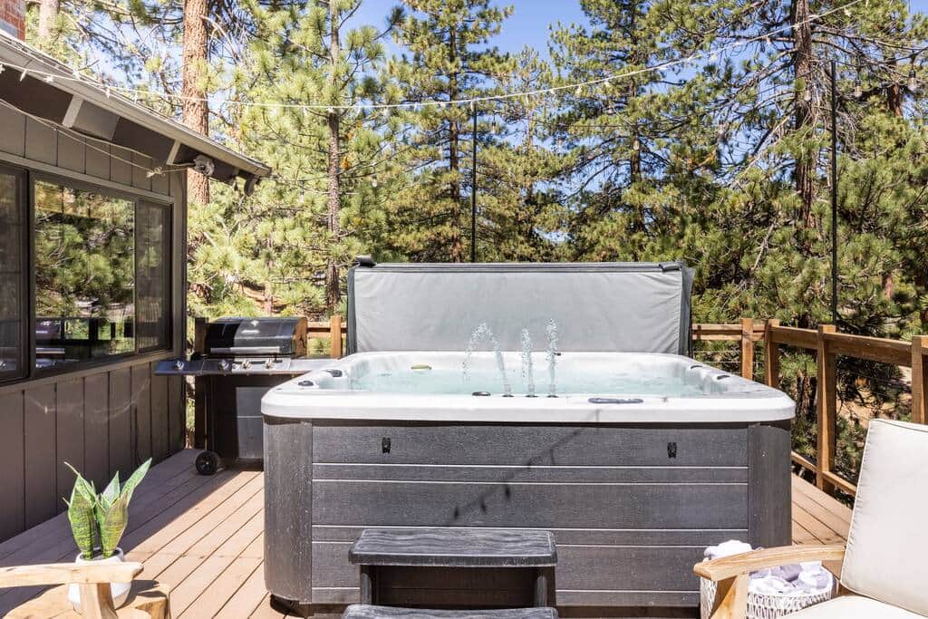 The expansive upper deck has a luxury hot tub with waterfall features, and grill/bbq.