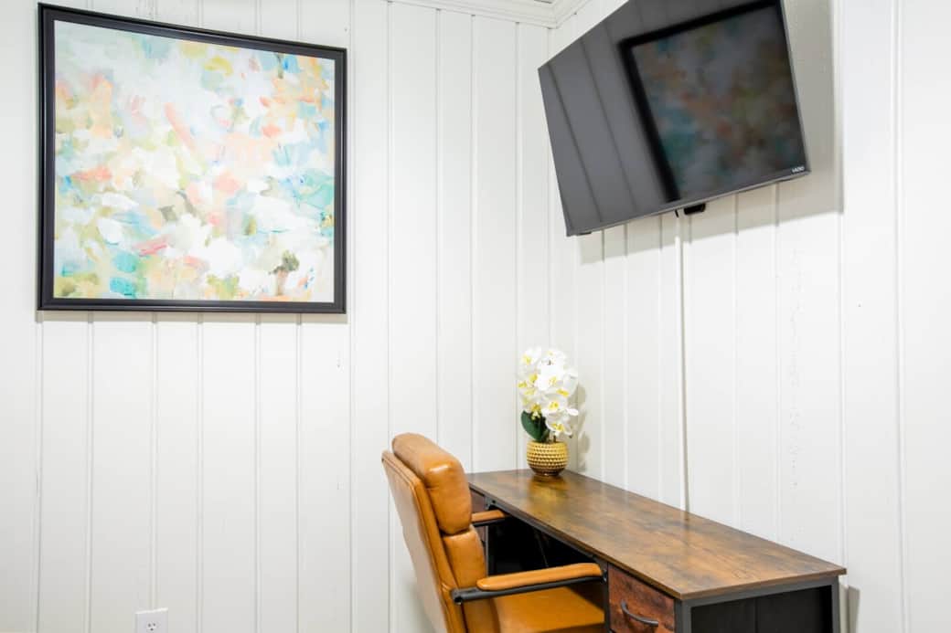 This great workspace features a desk with drawer storage, a 40" Smart TV that can be used for Zoom or Teams meetings, and a comfortable leather chair for long work sessions. 