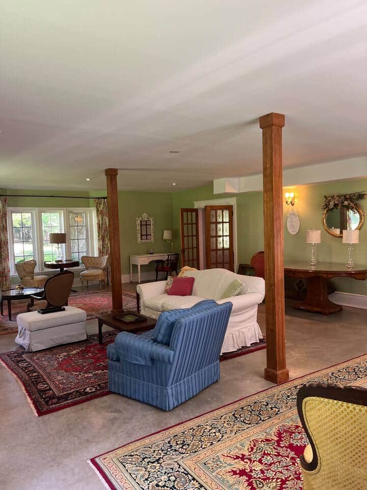 The Living Room looks onto the garden and has a wood burning fireplace, 3 book cases & 3 separate seating areas for conversation or reading privacy.