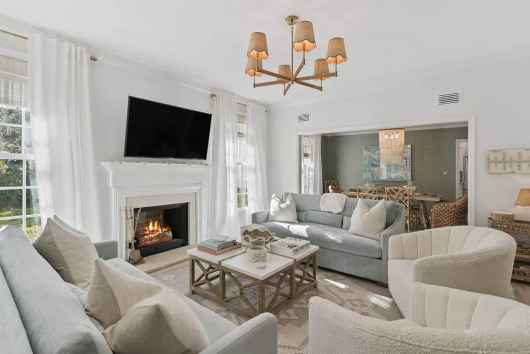 This elegant, cozy, elevated Living Room has velvet  sofas, boucle chairs, a TV and fireplace. 
