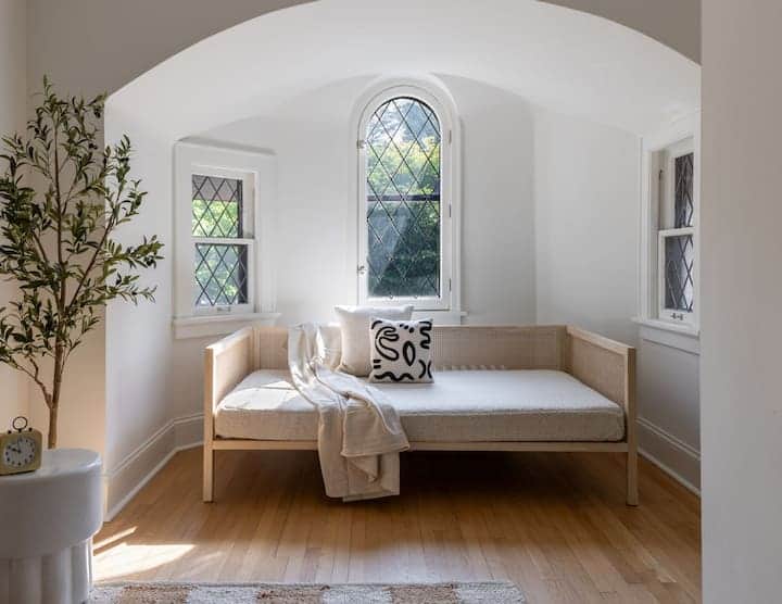 Charming arched alcove with leaded glass windows and a cozy daybed