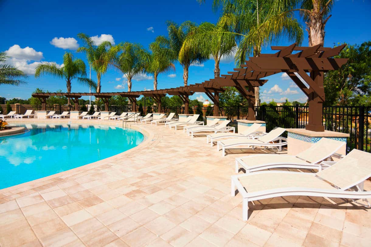 Beautiful community swimming pool area, lined with palm trees