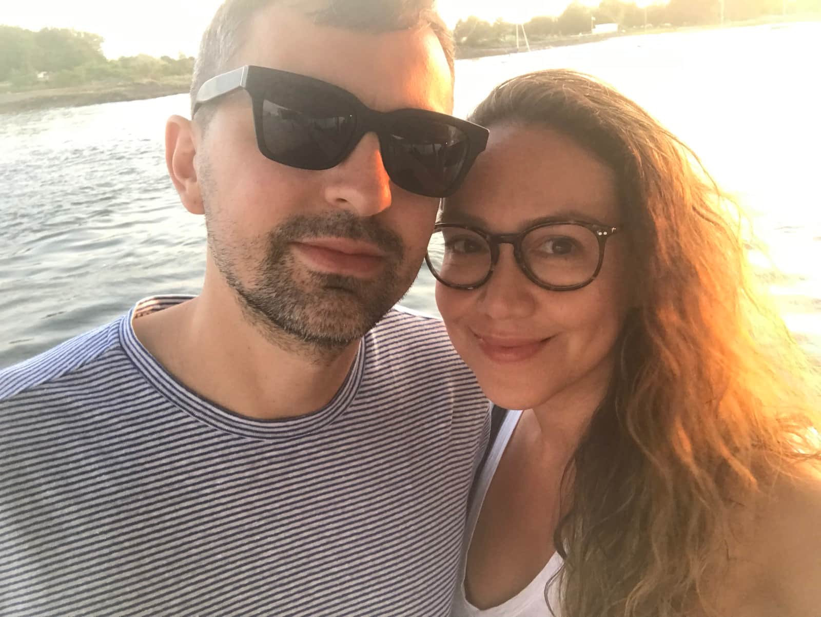 Chris and Yazzi, the hosts of Cerrito Encantado, by the water at sunset