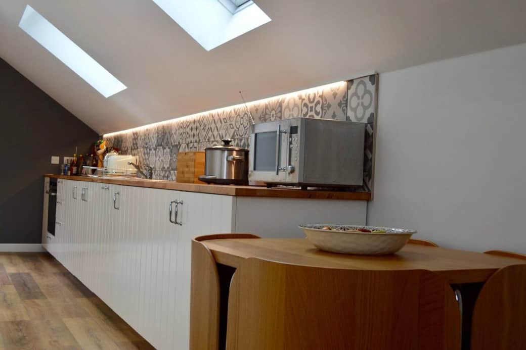 The gallery style kitchen includes oven, induction hob, fridge with freezer compartment, microwave, dishwasher, kitchen utensils, pans and cleaning items. The gallery style kitchen includes oven, induction hob, fridge with freezer compartment, microwave, dishwasher, kitchen utensils, pans and cleaning items.