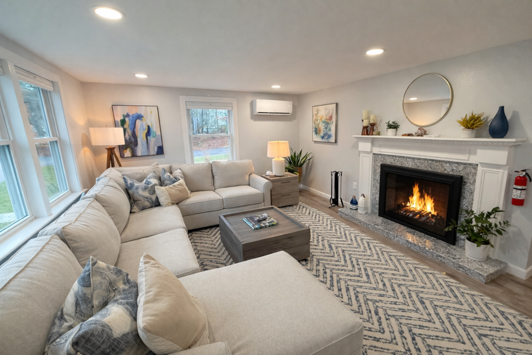 Main living room with a large sectional wood burning fireplace, 65" TV