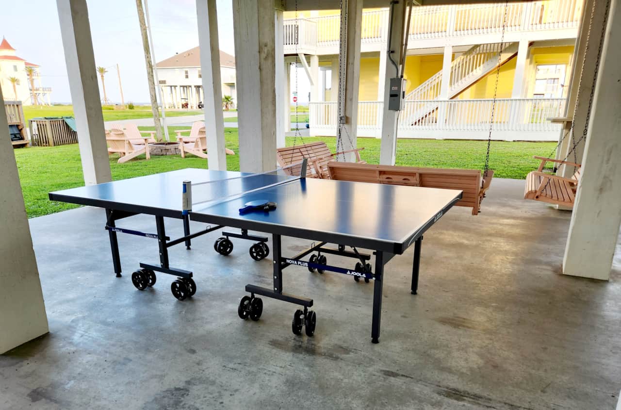 Amazing downstairs with outdoor ping pong, porch swing conversation set & fire pit w/ Adirondacks