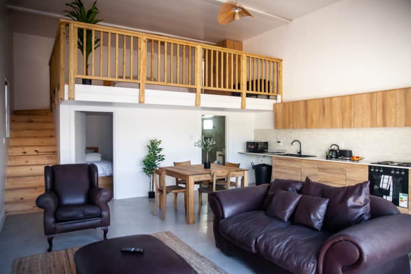 The open-plan living room at The Boathouse, with a timber mezzanine above the kitchen