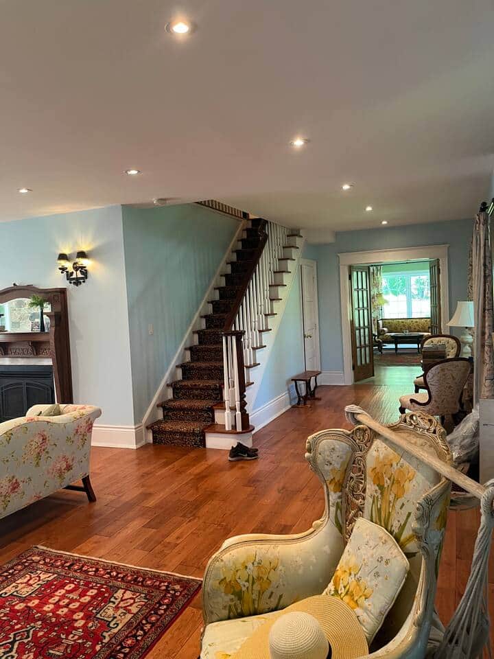The entrance of the house features an elegant reception room with gas fireplace, multiple seating areas  & a long interior stone wall built in the 1830's by Scottish stone masons