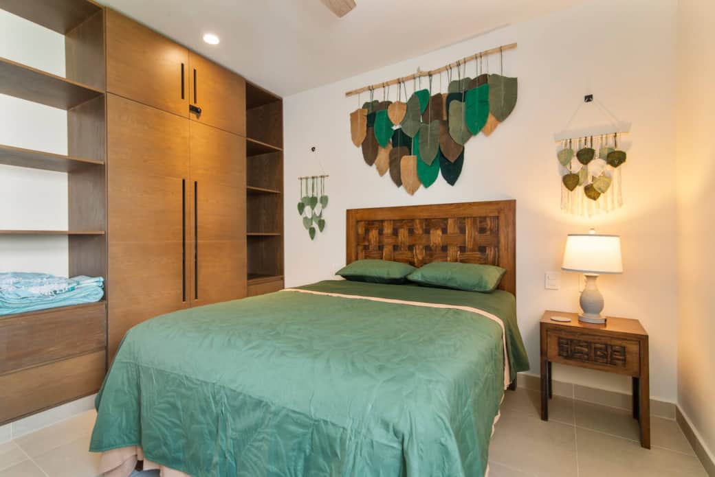 Bedroom with full wardrobe, nightstand switch, and easy-access charging outlets.