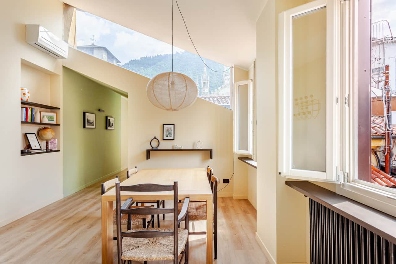 Essbereich mit Holzstühlen und grüner Wand, Licht vom Dachfenster