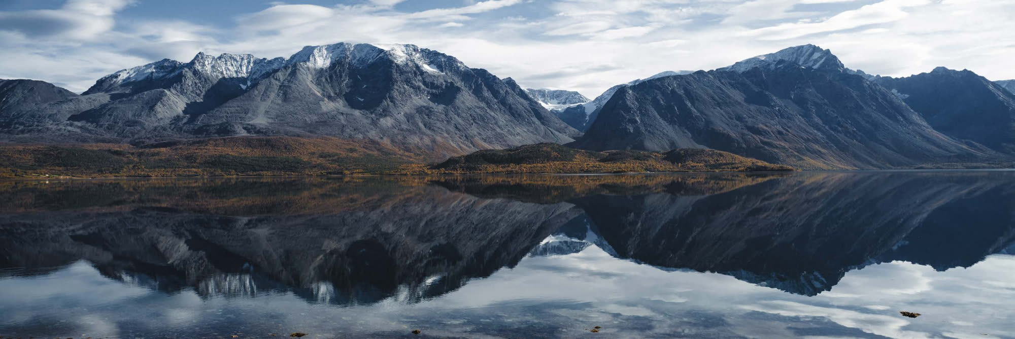 Autumn mountains mirrored in the fjord