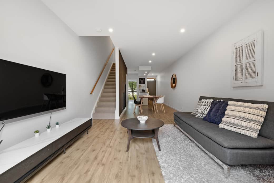Welcome to your cozy retreat in the heart of the city. This modern living room offers a comfortable gray sofa, perfect for relaxing after a day of exploration. The flat-screen TV is ideal for movie nights or catching up on your favorite shows. 