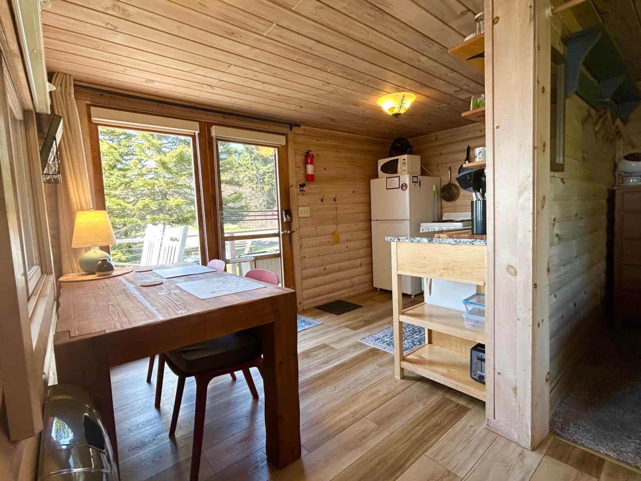 Enter the door from the deck into this tiny house kitchen eating area with new granite counters.