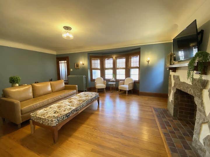 Spacious living room with warm hardwood floors, a charming fireplace, and plenty of seating.