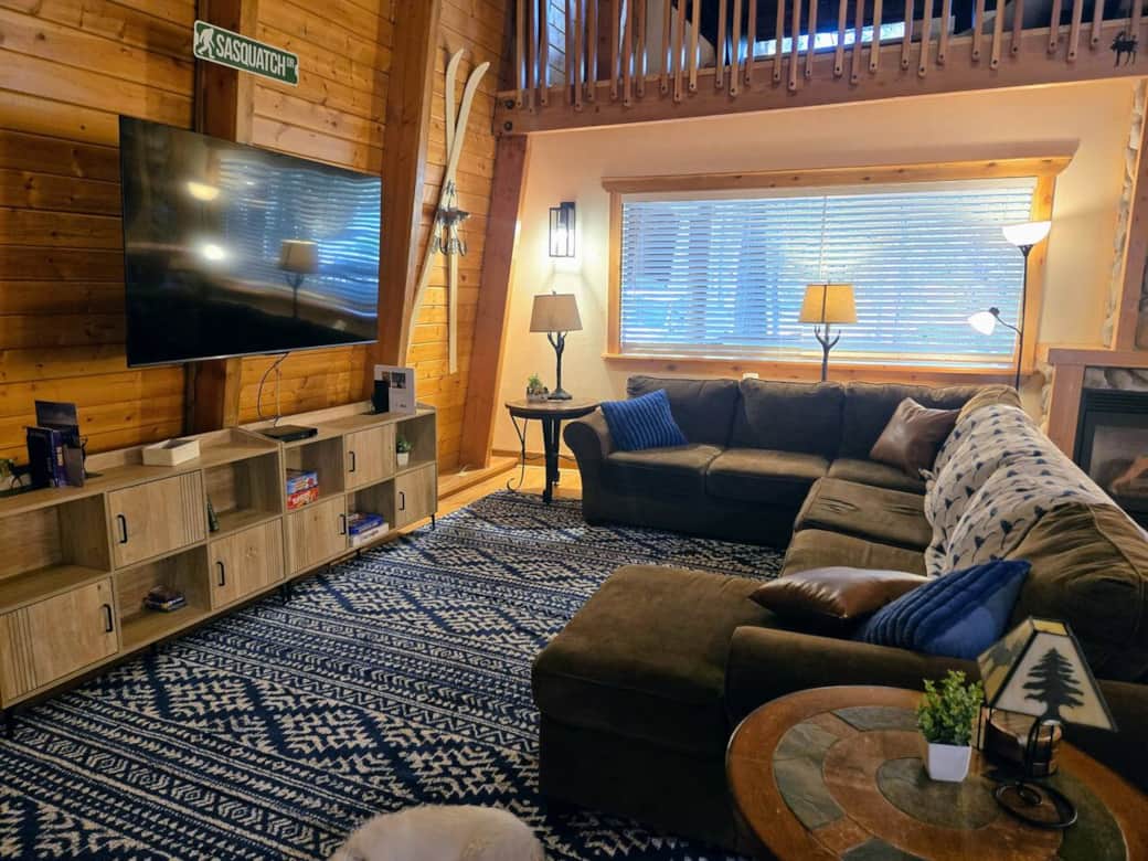Slow down and enjoy some cabin down time. Living room includes a sectional couch has a fold-out queen bed, smart TV, DVD player, and plenty of games.